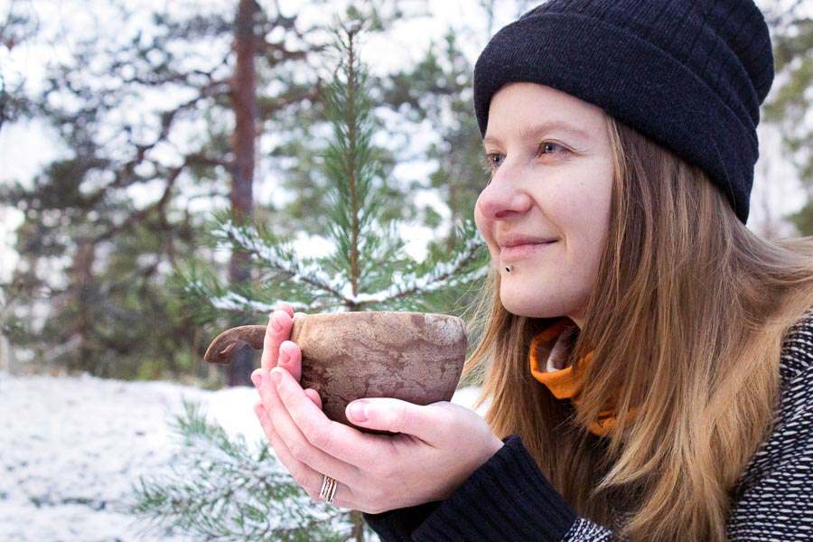 Kupilka 37 stor kåsa i händerna på en kvinna utomhus på vintern.