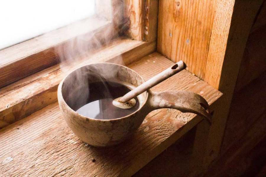 Kupilka kåsa 21 brun, i fönstersmyg med kaffe i.
