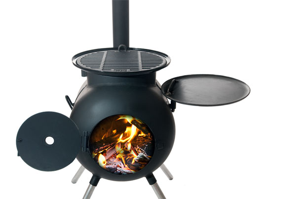 Ozpig med frontluckan öppen så att du kan se elden. Ovanpå grillgaller och stekplattan till höger.